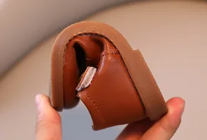 Gros plan sur la chaussure souple en cuir marron montrant la semelle en gomme flexible