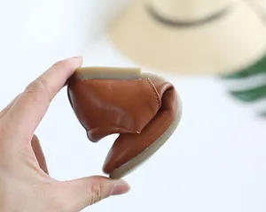 Detail of the flexible soft brown leather sole being folded to show comfort for toddlers