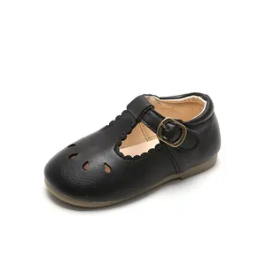 Classic black leather T-strap baby shoes with cutout details and flexible rubber sole