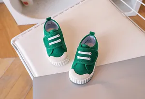 Detailed view of the bright green canvas shoe with non-slip white rubber sole and toe cap