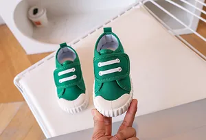 Detail of green canvas kids shoe featuring secure velcro strap and rubber toe cap
