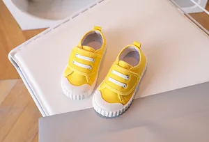 Top view of yellow toddler canvas sneakers with hook and loop closure and rubber toe cap