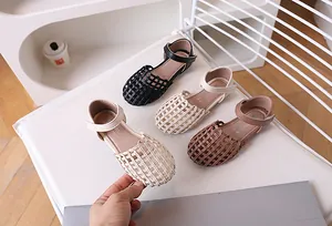Detailed overhead view of woven leather girls sandals in black, beige and brown colors