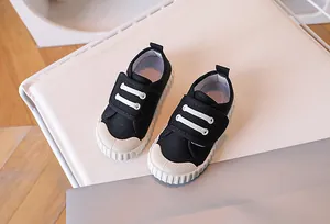 Detail view of anti-collision rubber toe and non-slip sole on black kids canvas shoes