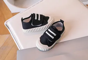 Detail of black children's canvas sneakers with double velcro straps and rubber sole
