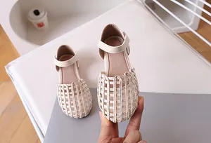 Close-up of beige woven girl's sandals featuring breathable mesh and velcro closure