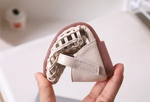 Detail of flexible non-slip sole on woven beige girls' sandals for toddler foot safety