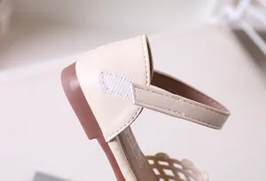 Detail of cream girls' sandals featuring velcro straps and fine stitching for kids