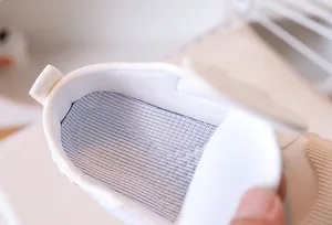 Detail view of breathable mesh insole and soft fabric lining in white canvas shoes