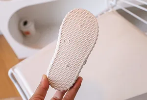 Detailed view of non-slip wavy texture and size mark 24 on white canvas shoe sole