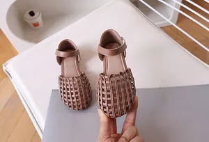 Detail of girls brown woven sandals featuring a protective closed toe and buckle strap