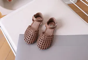 Top view of brown woven girls' sandals with mesh hollow toe and velcro straps