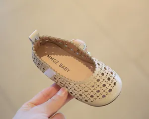 Detailopname van beige Mary Jane peuterschoenen met uitgesneden bloemmotief en klittenband