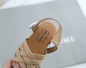 Detail of woven cross-strap sandals for girls with adjustable heel strap and logo