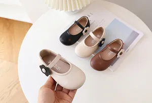 Detailaufnahme von Mary-Jane-Mädchenschuhen mit Blumendekor in Schwarz, Creme und Braun