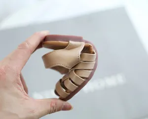 Close-up of flexible soft rubber sole and woven strap design on girls' sandals