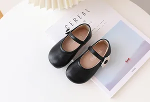 Nahaufnahme schwarzer Mädchen Mary Jane Schuhe mit weißer Blume auf einer Zeitschrift