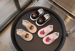 Détail de chaussures en toile pour enfants avec broderie ours et semelles antidérapantes