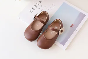 Detail von braunen Mädchen-Mary-Janes mit 3D-Blumenakzent und mattem Finish für Kinder