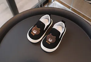 Vue détaillée des chaussures en toile noire pour enfants avec broderie ours sur le dessus