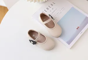 Detailansicht der beigen Mary Jane Kinderschuhe mit schwarzer Blume und Klettverschluss