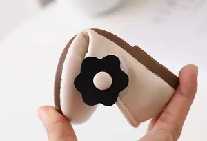 Nahaufnahme cremefarbener Babyschuhe aus Leder mit hochflexibler brauner Gummisohle