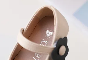 Detailansicht beige Mädchen-Mary-Jane mit schwarzer Blume und feinen Nähten