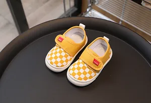 Detail of yellow checkerboard canvas toddler shoes with velcro strap and rubber sole