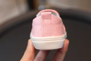 Détail du talon de chaussure en toile rose pour enfant avec languette et semelle