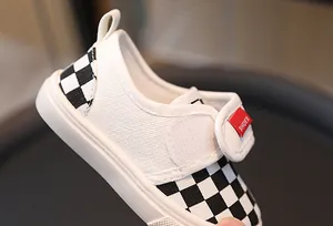 Detail of children checkerboard canvas shoes with adjustable hook and loop closure