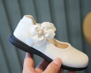 Détail de chaussure Mary Jane blanche pour fille avec fleur 3D et centre en perles et strass