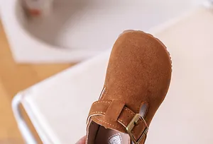 Gros plan détaillé de chaussures en daim pour enfants avec couture et boucle métal