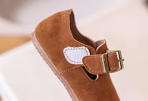 Détail de chaussures en daim marron pour enfants avec boucle métal et velcro pratique