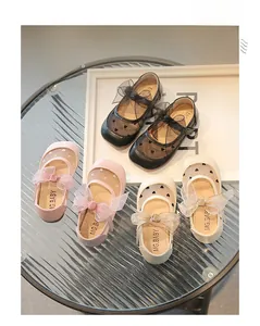 Dettaglio di scarpe Mary Jane per bambini con fiocco in rete e motivi a pois cuore