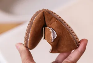 Gros plan d'une chaussure enfant en daim marron montrant une grande souplesse de semelle