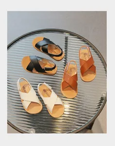 Flat lay of breathable leather sandals for kids in black, brown and white colors