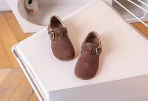 Gros plan de chaussures en daim marron pour enfants avec boucle métallique élégante