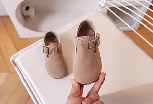 Gros plan de chaussures rétro en daim kaki pour enfants avec boucle en métal vintage