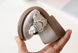 Detail showing high flexibility of beige girls princess shoes with pearl and heart buckle