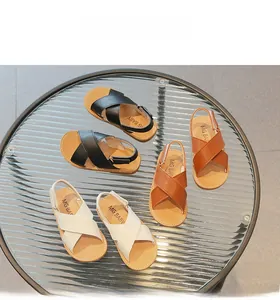 Three pairs of kids leather sandals in black, brown, and beige with cross-strap design