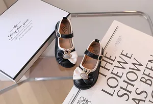 Dettaglio di scarpe Mary Jane da bambina con ciondolo a coniglio in metallo e fiocco