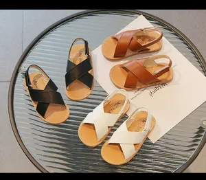Detailed view of kids' leather sandals in brown, black, and white with velcro straps