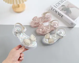 Close-up of girls princess sandals with pearl bow detailing and iridescent finish