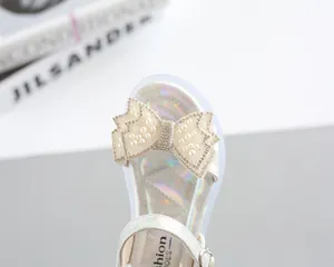 Detail of girls princess sandals with pearlescent bow and shimmering rhinestones