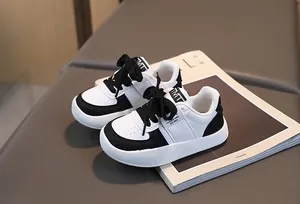 Détail de baskets classiques noir et blanc pour enfants avec perforations et étiquette