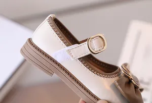 Dettaglio di scarpe Mary Jane per bambine con decorazione a fiocco e cuciture a contrasto