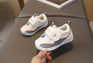 Détail de chaussures bébé avec mesh respirant et coutures contrastées orange et gris