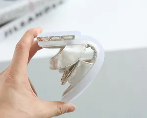 Close-up showing the extreme flexibility of the soft sole on these girl's pearl sandals