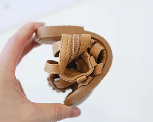 Macro detail of the ultra-flexible brown rubber sole on girl's roman gladiator sandals