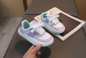 Détail de baskets enfant blanches avec des touches de violet pastel rose et vert menthe